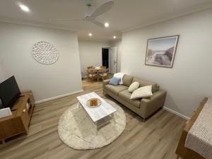 a living room with a couch and a table at Bunbury Ocean Views in Bunbury