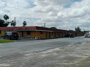 a yellow building with cars parked in a parking lot at Budget Inn By OYO Edinburg Hwy 281 in Edinburg +24 photos