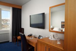 Una televisión o centro de entretenimiento en Hotel Örk