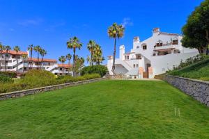 a large white house with palm trees in the background at H178 - Hamilton Cove Villa 1-78 in Avalon