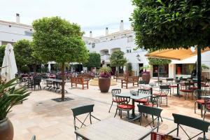 an outdoor patio with tables and chairs and trees at Moderno apartamento en La Manga Club in Atamaría