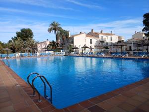 a large blue swimming pool with blue chairs and buildings at Moderno apartamento en La Manga Club in Atamaría
