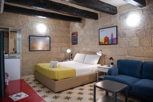 Un dormitorio con una cama y un sofá azul. en Casa San Carlo, en La Valeta
