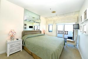 a bedroom with a bed and a chair and a television at H178 - Hamilton Cove Villa 1-78 in Avalon +18 photos