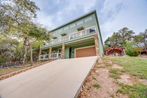 an exterior view of a green house with a driveway at Less Than 1 Mi to Comal Park Peaceful Duplex with Yard! in Canyon Lake