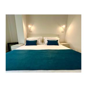 Un dormitorio con una cama grande con dos almohadas azules. en Pirandello 181, en Palermo