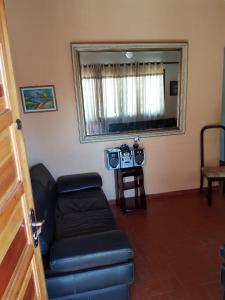 a living room with a couch and a mirror at Casa de praia in Itanhaém