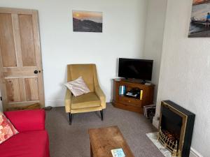 Una sala de estar con un sofá y un televisor. en Bay View, en Swanage