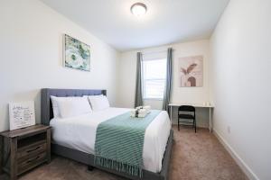 Un dormitorio con una cama y un escritorio y una ventana. en Near Disney Deluxe Room A, en Kissimmee