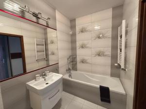 a bathroom with a sink and a tub and a toilet at Apartament in Giżycko +6 photos