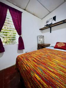 Un dormitorio con una cama con una manta colorida. en Natural Mystic, en Santa Ana