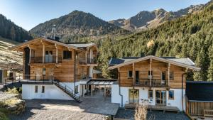 ein Haus mit Bergen im Hintergrund in der Unterkunft Weidenchalets in Sellrain
