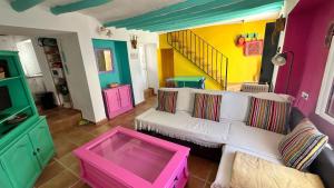 a living room with a white couch and colorful walls at La Casa de los Colores in Olvera