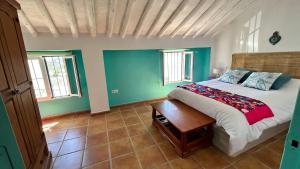 a bedroom with a bed and a table in it at La Casa de los Colores in Olvera