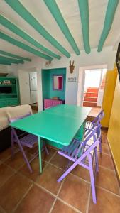 a green ping pong table in a room with chairs at La Casa de los Colores in Olvera