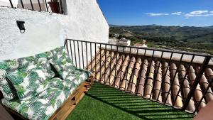 a couch sitting on a balcony with a view at La Casa de los Colores in Olvera
