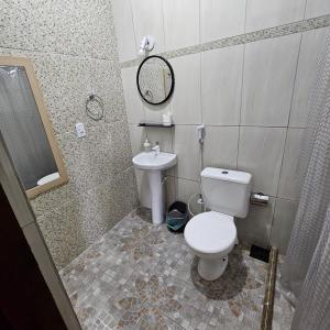 a bathroom with a toilet and a sink at KITNET Beira Mar Prainha Barra - Rio das Ostra in Barra de São João