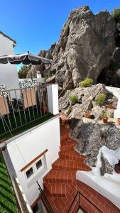 a house with a staircase leading to a rock at La Casa de los Colores in Olvera +17 photos