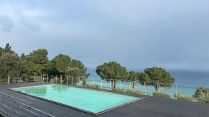 a swimming pool on a deck with the ocean in the background at Pini, a Paradise Oasis in Finale