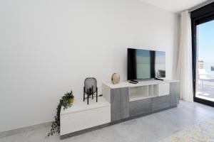 ein Wohnzimmer mit einem Fernseher an einer weißen Wand in der Unterkunft Casa Clara in Villacosta