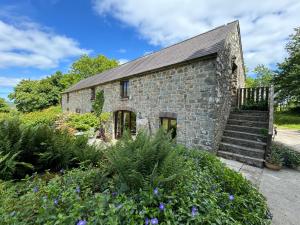 a stone house with a garden in front of it at Stable Cottage in Newport Pembrokeshire