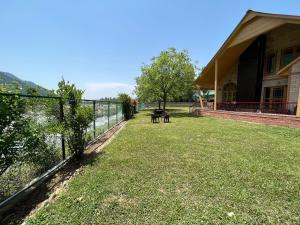 a yard with a fence and a picnic table at Birdsong in Pahalgām