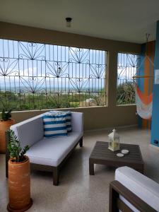 a living room with a couch in front of a window at Kassa Wista Azzul Rentals-with pool in Hormigueros +16 photos