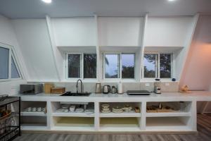a kitchen with a large white counter with windows at Casa Clara Monteverde in Puntarenas