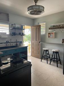 a kitchen with two bar stools and a counter top at Kassa Wista Azzul Rentals-with pool in Hormigueros