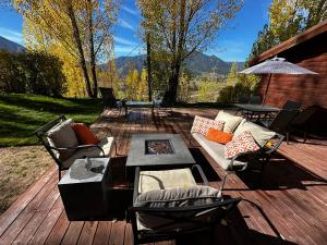 een terras met een bank, stoelen en een parasol bij Cozy Cabin on Hiking Trailhead & Elk Preserve in Garden Valley