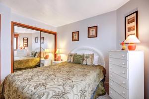a bedroom with a bed and a dresser and a mirror at H230 - Hamilton Cove Villa 2-30 in Avalon +22 photos