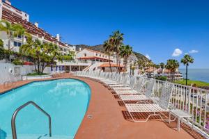 a swimming pool with lounge chairs and the ocean at H230 - Hamilton Cove Villa 2-30 in Avalon