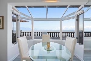 a dining room with a glass table and chairs at H242 - Hamilton Cove Villa 2-42 in Avalon