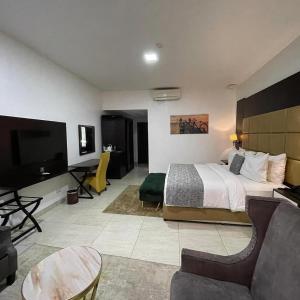 ニューデリーにあるHotel Olive Suites Delhi International Airportのベッドと薄型テレビがあるホテルの部屋