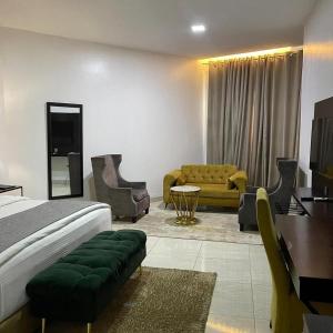 ニューデリーにあるHotel Olive Suites Delhi International Airportのベッドルーム1室(ベッド1台、デスク、ソファ付) +16枚の写真