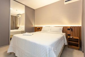 a bedroom with a large white bed and a mirror at Travel Inn Premium Flats Paulista Wall Street in Sao Paulo +34 photos