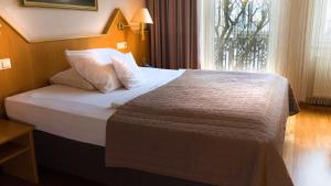 a large bed in a hotel room with a window at Komfort Hotel Am Kurpark in Bad Homburg vor der Höhe