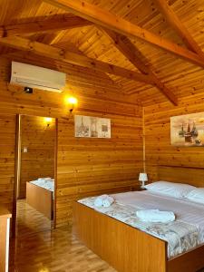 a bedroom with two beds in a wooden cabin at The Mussel House in Ksamil