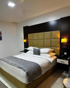 ニューデリーにあるHotel Olive Suites Delhi International Airportのベッドルーム1室(大型ベッド1台、大型ヘッドボード付)