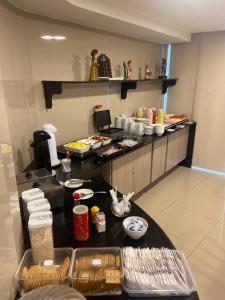 a kitchen with a counter with food on it at Hotel Enseada Aeroporto in Recife