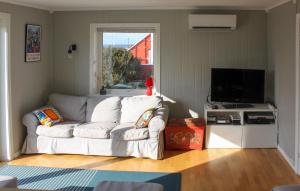 a living room with a white couch and a television at 5 Bedroom Nice Home In Borhaug in Borhaug