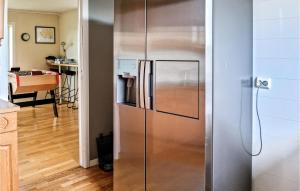 a stainless steel refrigerator in a kitchen at 5 Bedroom Nice Home In Borhaug in Borhaug +26 photos