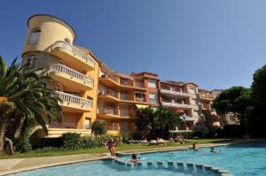 a group of people in a swimming pool in front of a building at Bertur Gran Reserva Comte Empuries in Empuriabrava