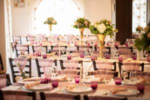 a room filled with tables and chairs with flowers at Pensiune Restaurant Indus in Ocna Sibiului