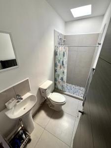 a bathroom with a toilet and a shower and a sink at Casa exclusiva con alberca en privada Cerca de Galería in Mazatlán