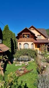 a house with a garden in front of it at Casa Georgeta in Câmpulung Moldovenesc
