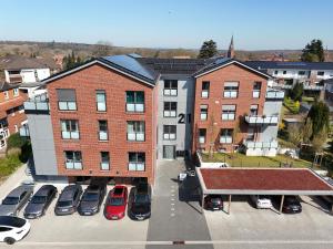 an apartment building with cars parked in a parking lot at Stilvoll-möbliertes Apartment in Harsefeld