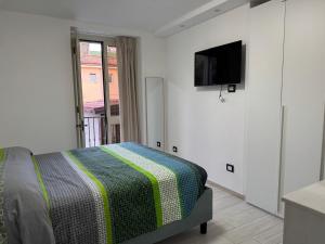 a bedroom with a bed and a flat screen tv at Palummella in Sapri