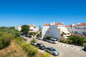 a city street with cars parked in a parking lot at Fresh & Breezy Tavira Apartment in Cabanas de Tavira