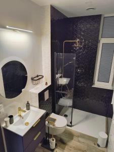 a bathroom with a toilet and a sink and a shower at Century Apartment in Wrocław
